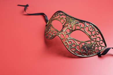 Photo of Beautiful carnival mask on red background, space for text