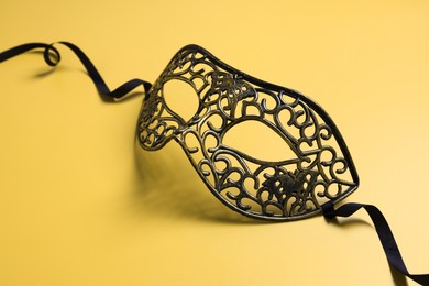 Photo of One beautiful carnival mask on yellow background