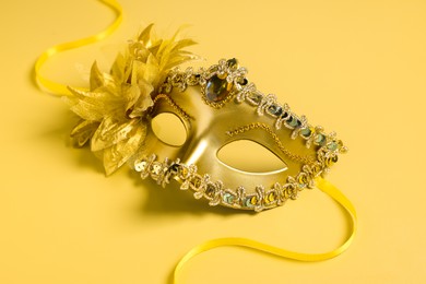 Photo of One beautiful carnival mask on yellow background