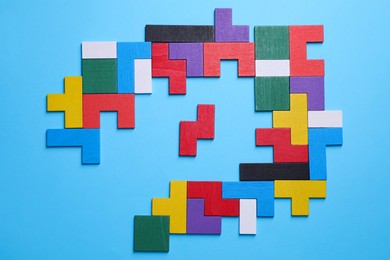 Colorful wooden puzzle pieces on light blue background, top view