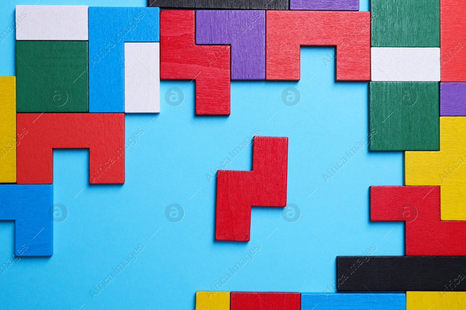 Photo of Colorful wooden puzzle pieces on light blue background, top view