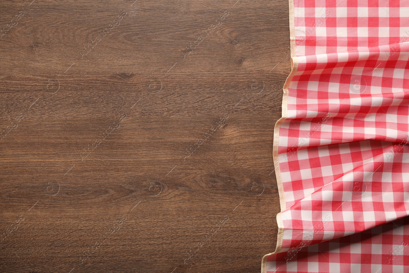 Red checkered picnic tablecloth on wooden table, top view. Space for text Photo of Red checkered picnic tablecloth on wooden table, top view. Space for text