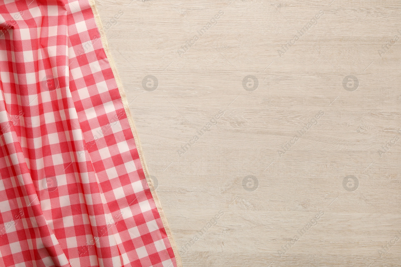 Red checkered picnic tablecloth on wooden table, top view. Space for text Photo of Red checkered picnic tablecloth on wooden table, top view. Space for text