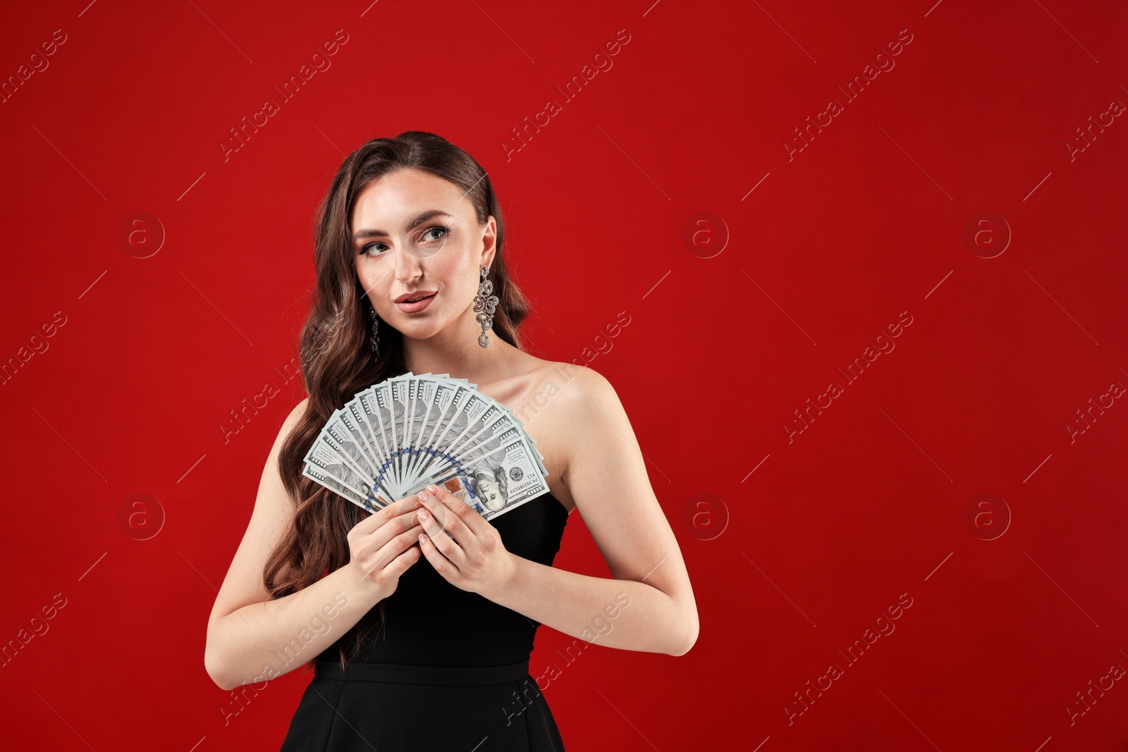 Photo of Charming woman with dollar banknotes on red background. Space for text