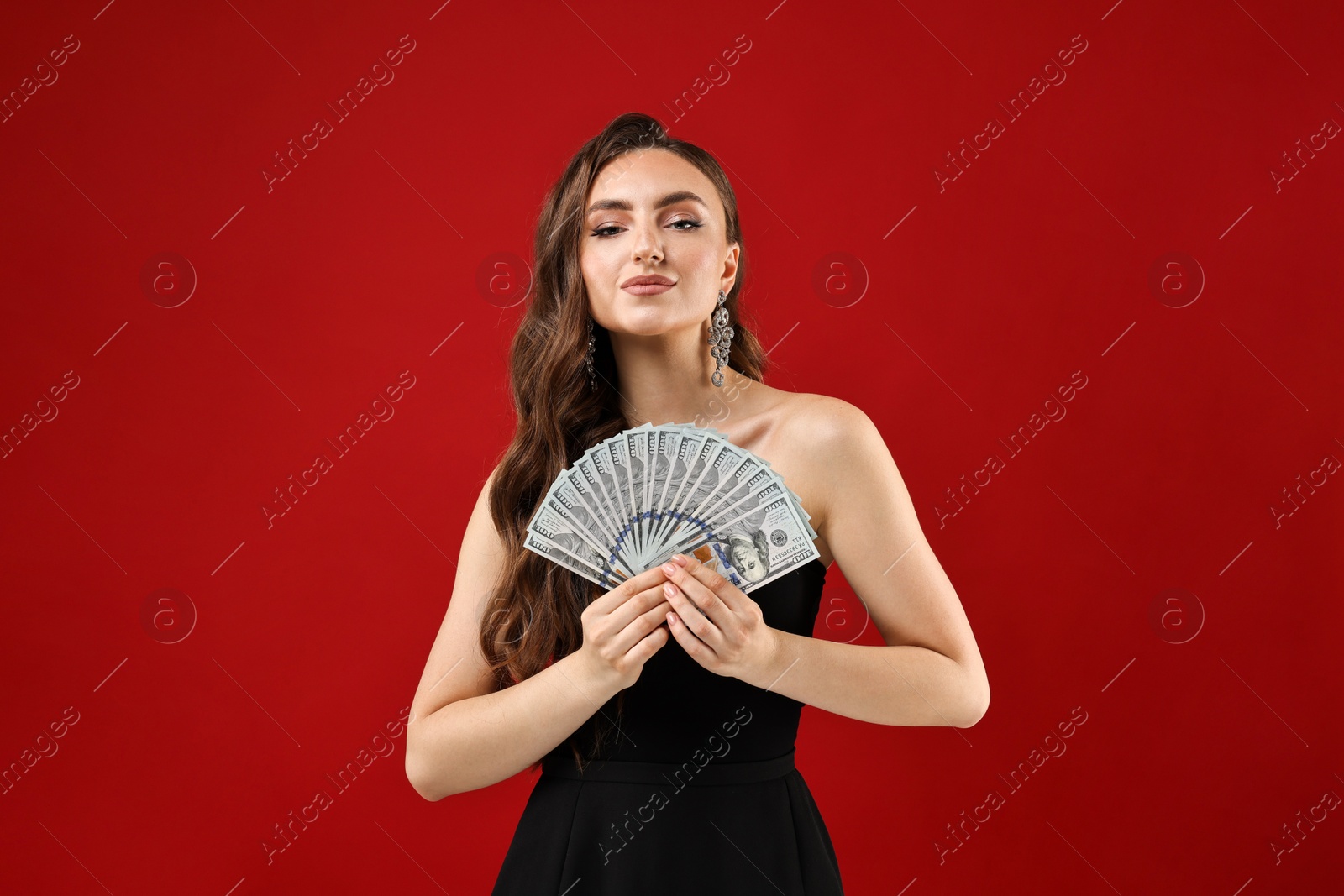 Photo of Charming woman with dollar banknotes on red background