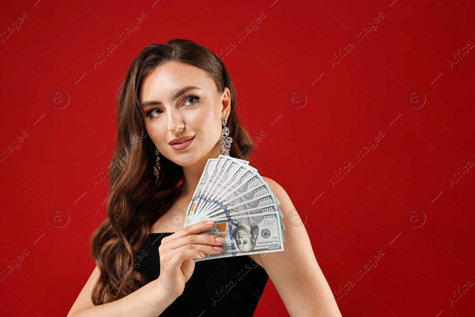 Photo of Charming woman with dollar banknotes on red background. Space for text