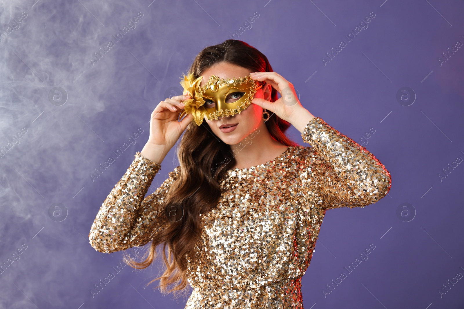 Photo of Beautiful woman wearing carnival mask on purple background with smoke