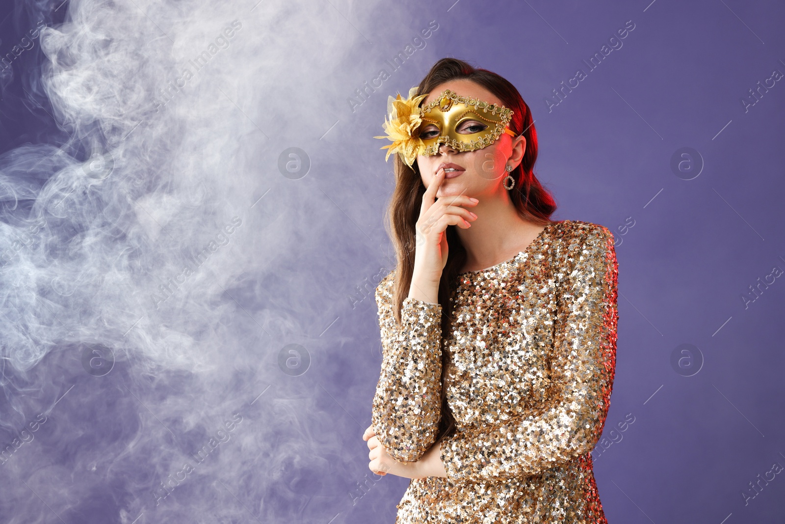 Photo of Beautiful woman in carnival mask on purple background with smoke. Space for text