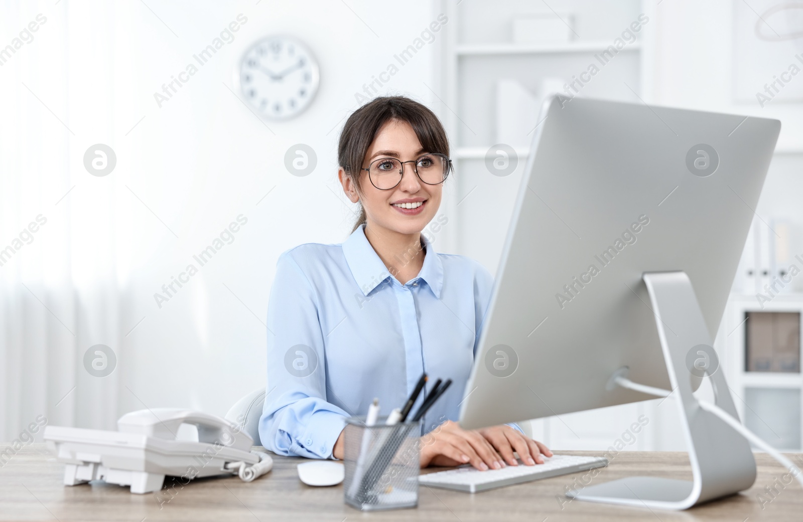 Photo of Professional receptionist working at wooden desk in office