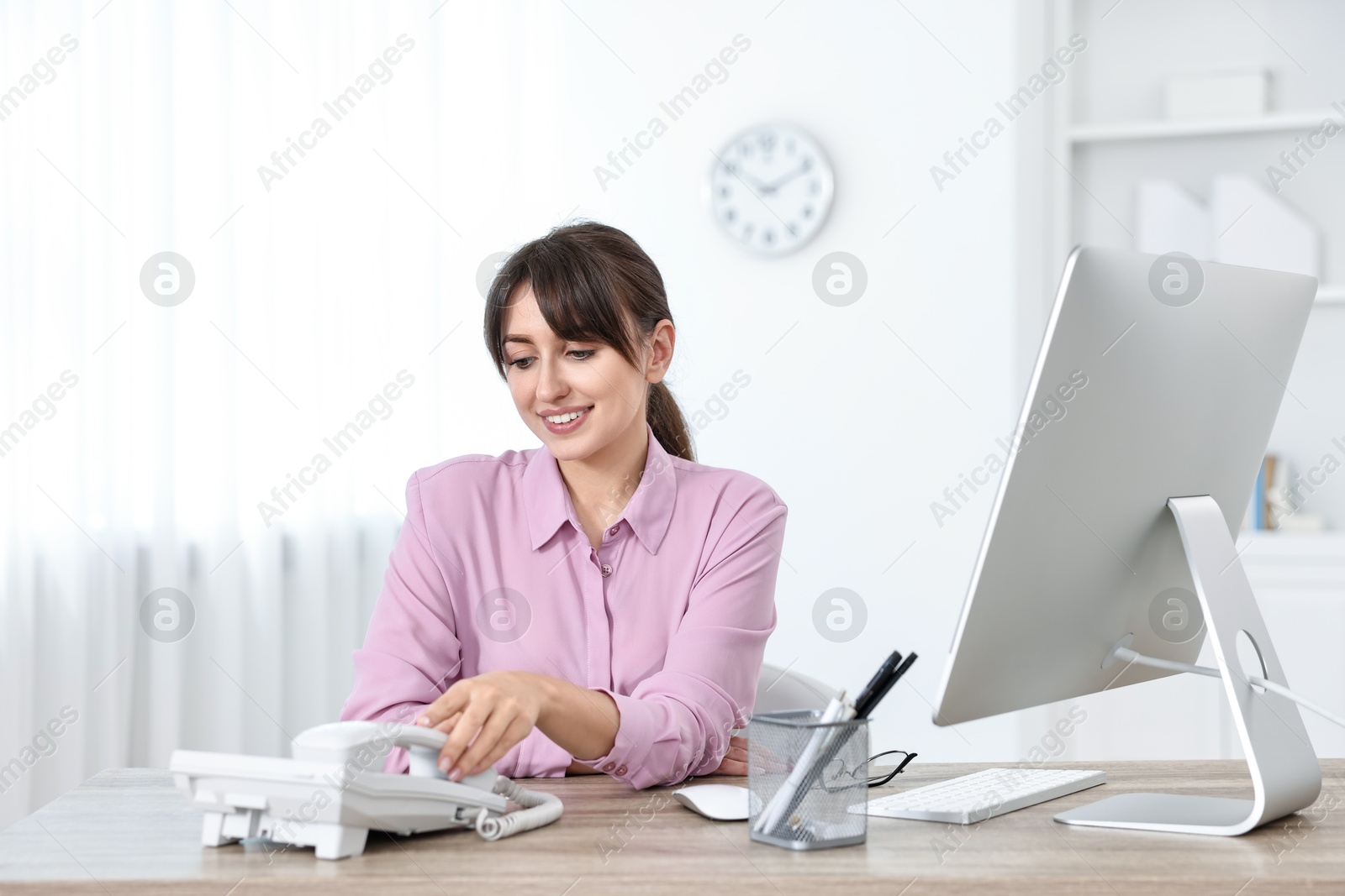 Photo of Professional receptionist working at wooden desk in office