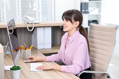 Professional receptionist working at wooden desk in office