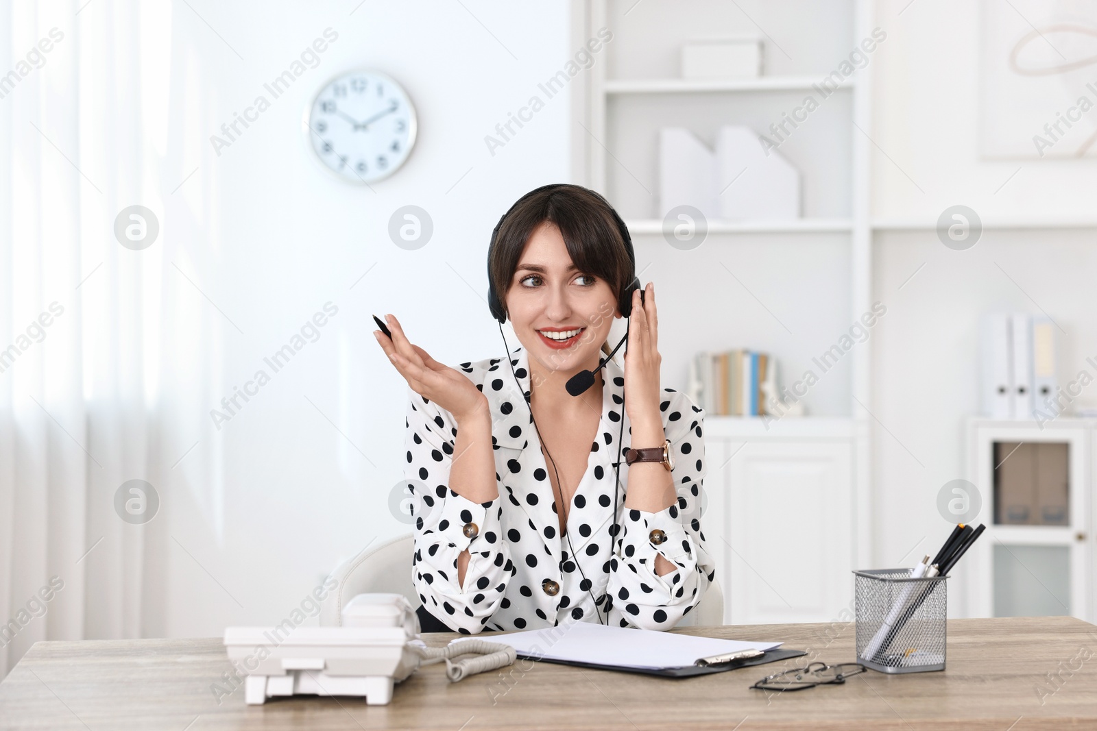 Photo of Professional receptionist working at wooden desk in office