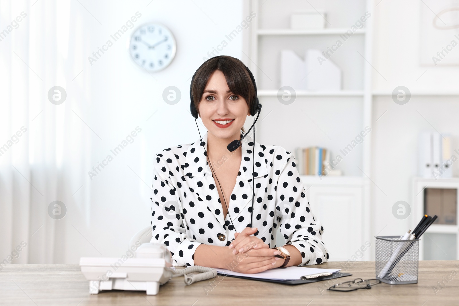 Photo of Portrait of receptionist at wooden desk in office