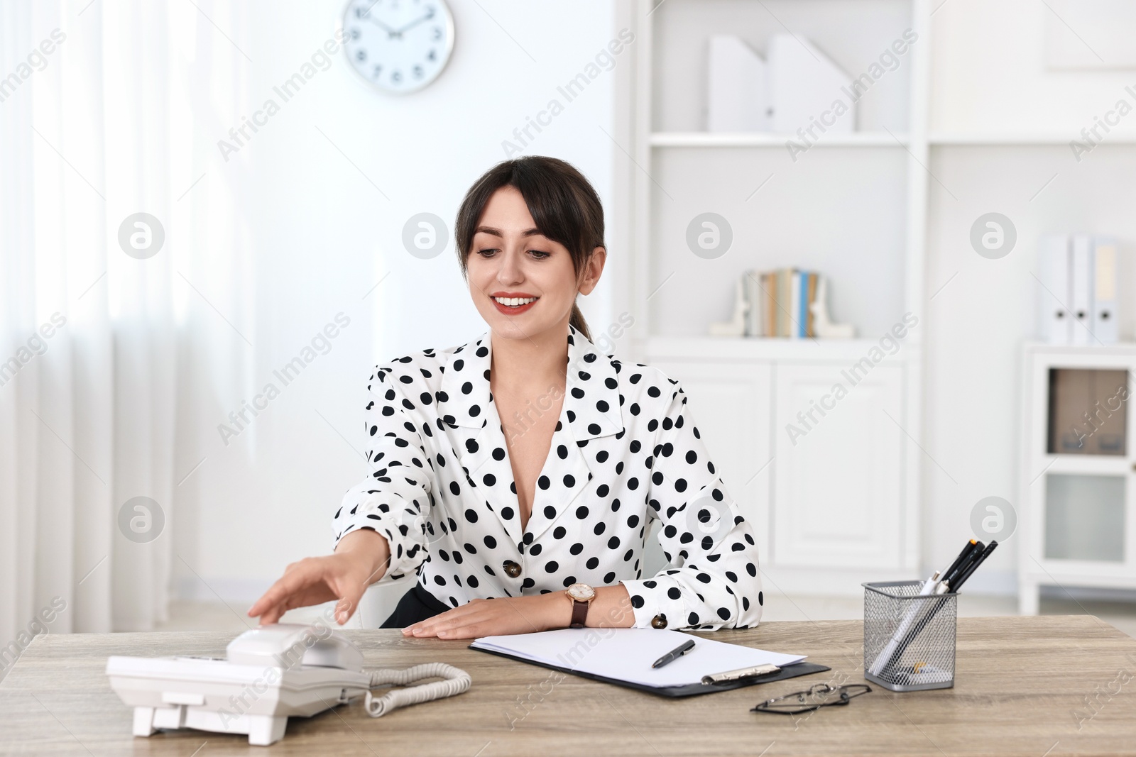 Photo of Professional receptionist working at wooden desk in office