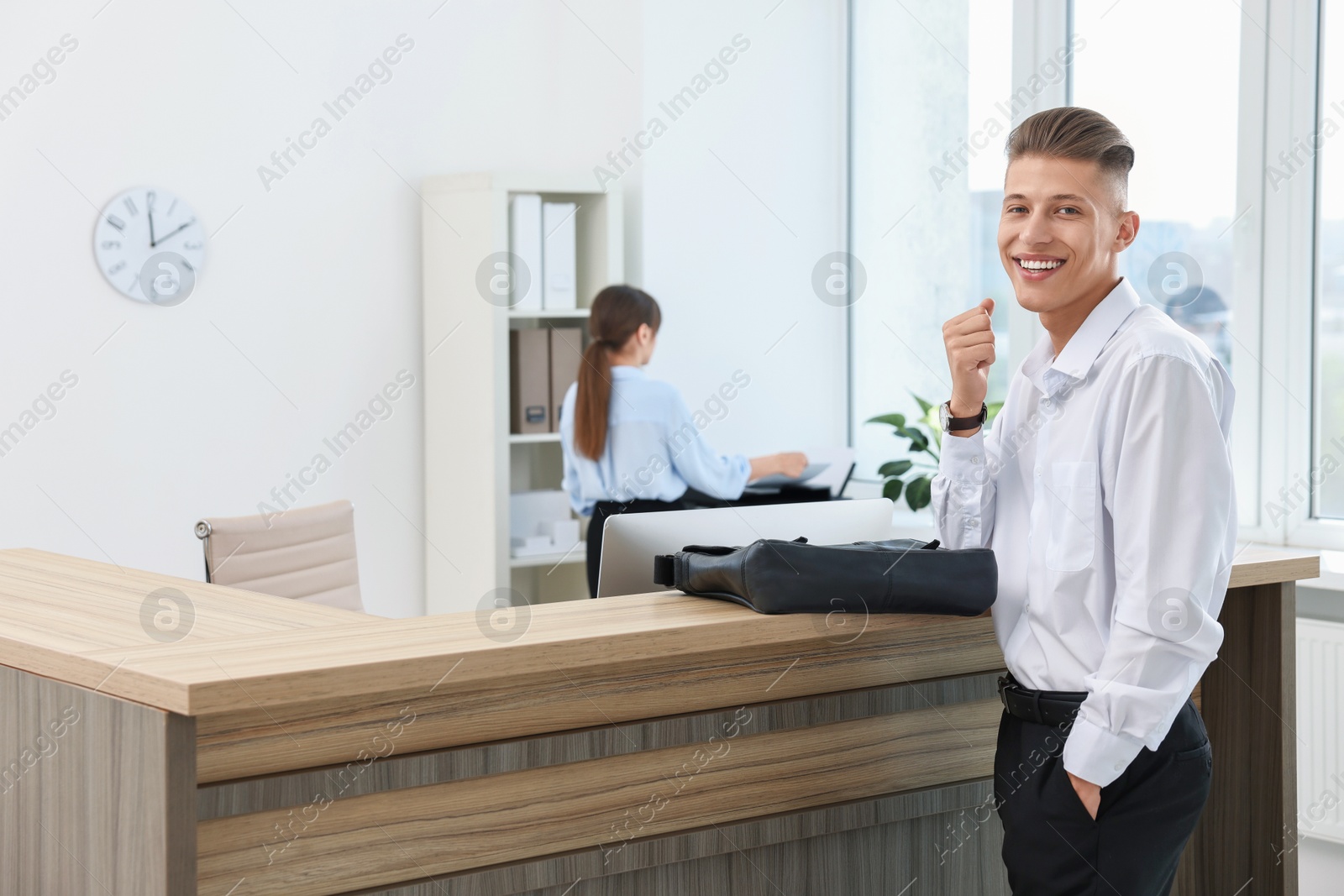 Photo of Professional receptionist and happy client in office