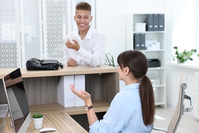 Photo of Professional receptionist working with client in office