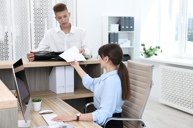 Professional receptionist working with client in office