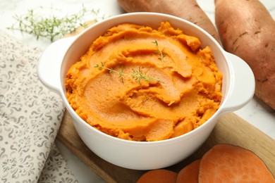 Photo of Delicious mashed sweet potatoes in pot and vegetables on table, closeup