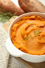 Photo of Delicious mashed sweet potatoes in pot and vegetables on table, closeup