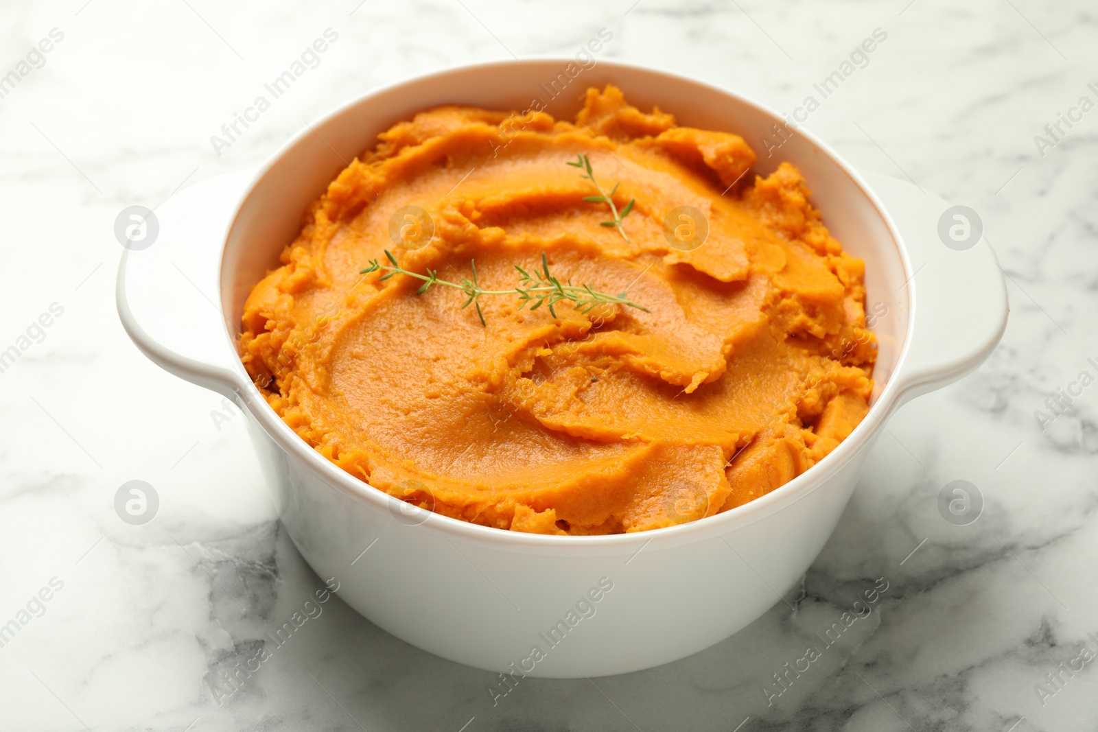 Photo of Delicious mashed sweet potatoes in pot on white marble table, closeup