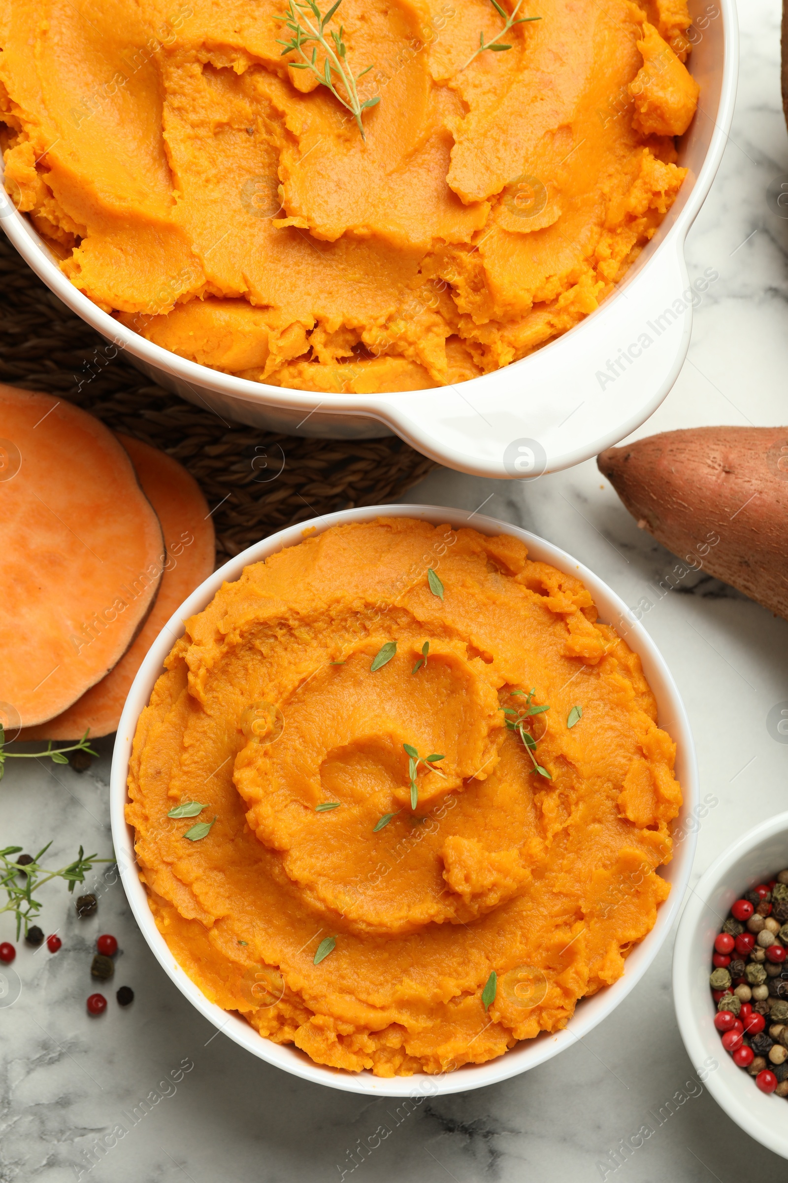 Photo of Delicious mashed sweet potatoes, spices and vegetable on white marble table, top view