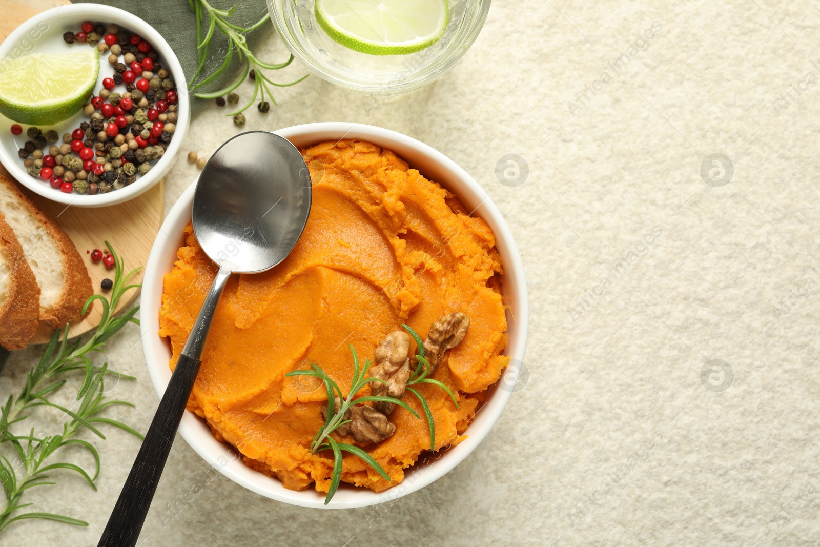 Photo of Delicious mashed sweet potatoes served on light table, top view. Space for text