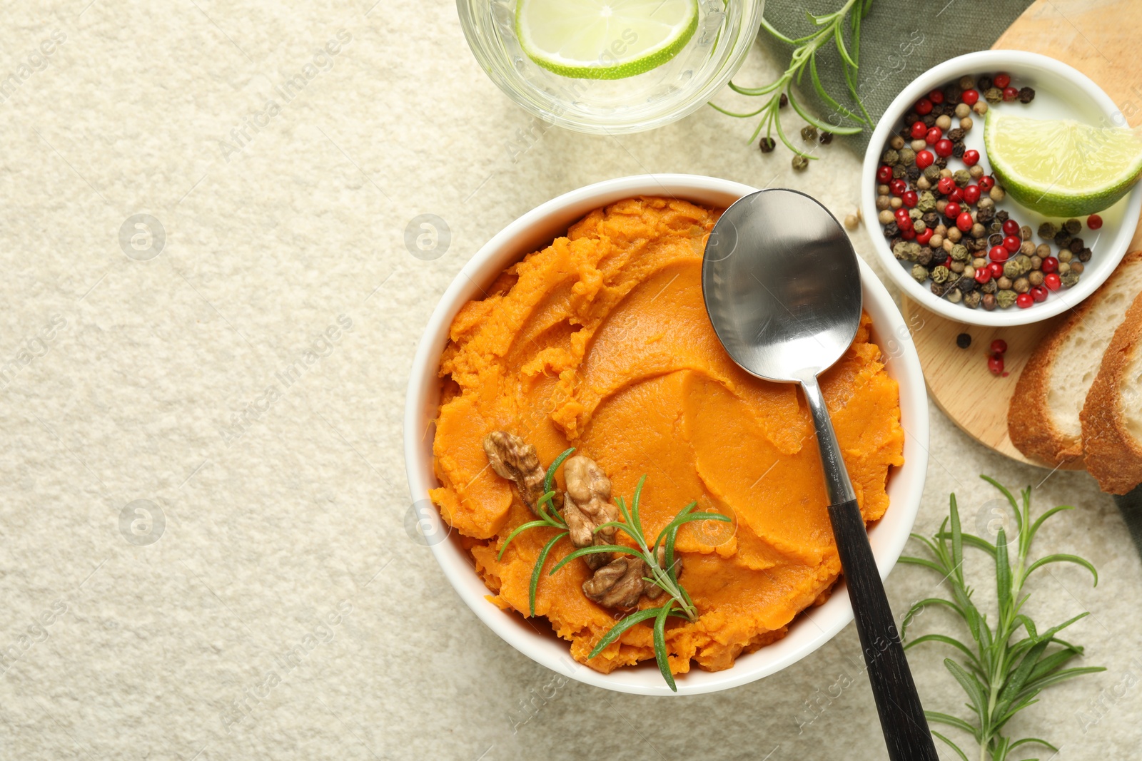 Photo of Delicious mashed sweet potatoes served on light table, top view. Space for text