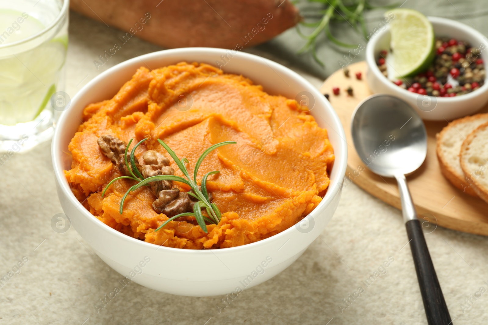 Photo of Delicious mashed sweet potatoes served on light table, closeup