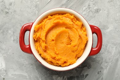 Delicious mashed sweet potatoes in pot on grey table, top view