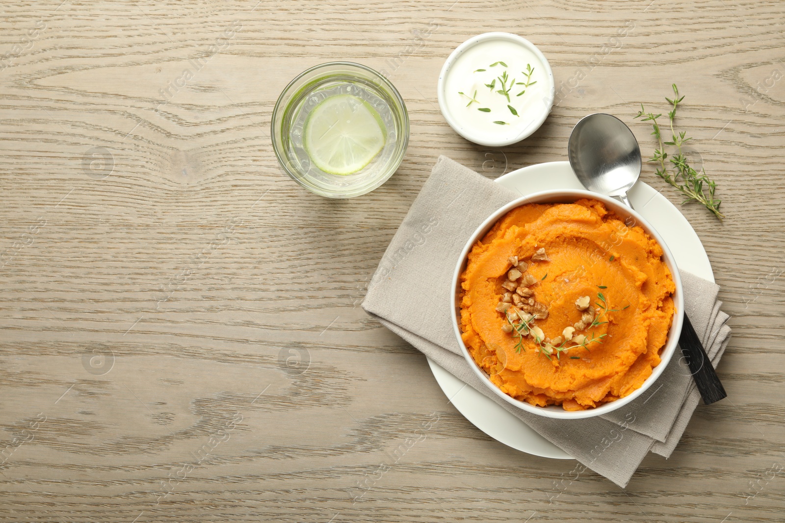 Photo of Delicious mashed sweet potatoes served on wooden table, top view. Space for text