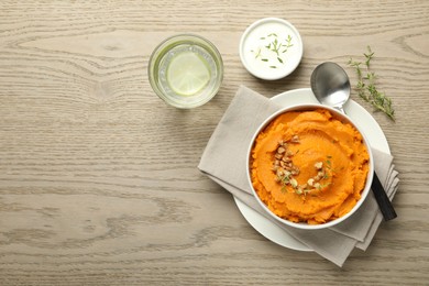 Photo of Delicious mashed sweet potatoes served on wooden table, top view. Space for text