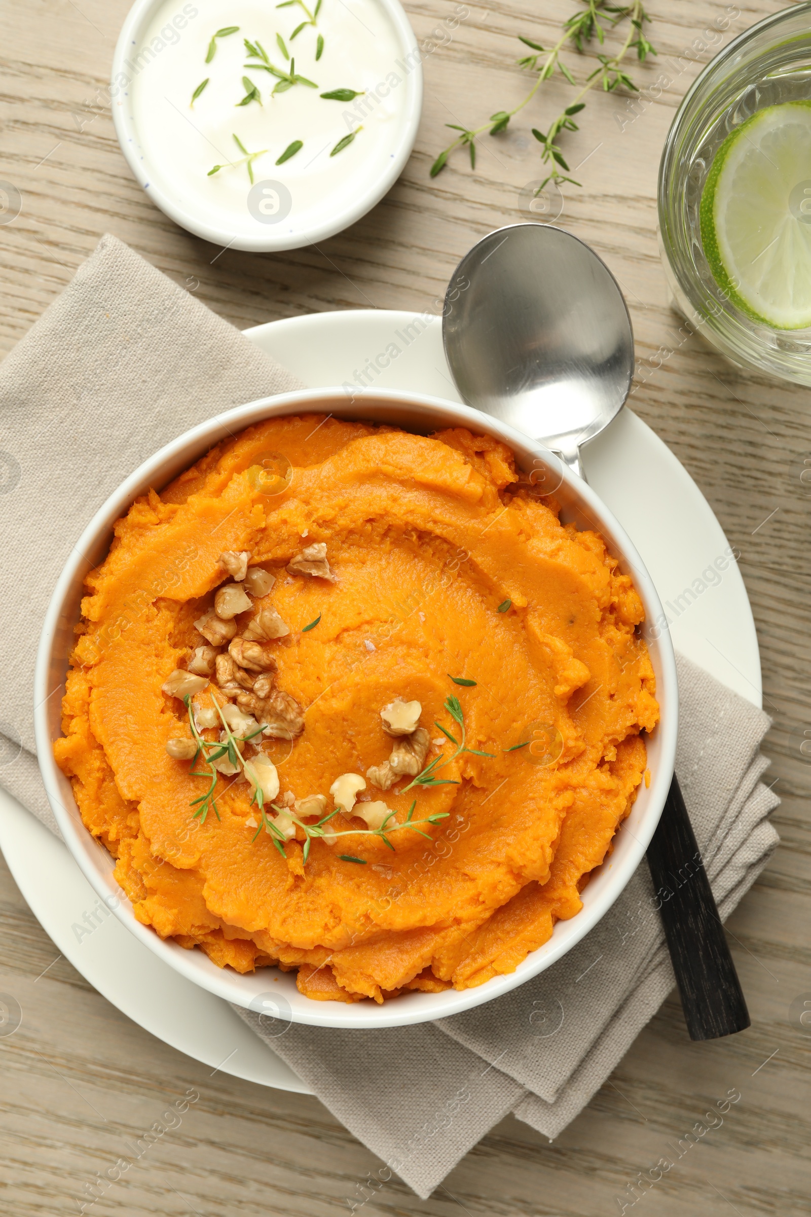 Photo of Delicious mashed sweet potatoes served on wooden table, top view