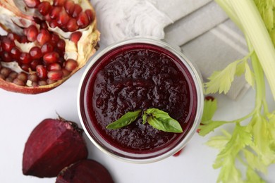 Photo of Fresh beetroot smoothie with mint, beet and pomegranate on white table, flat lay. Vegan drink