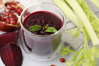 Fresh beetroot smoothie with mint in glass on white table, closeup