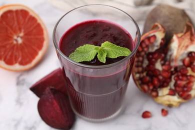 Fresh beetroot smoothie with mint in glass on white table, closeup. Vegan drink