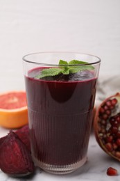 Photo of Fresh beetroot smoothie with mint in glass on white table, closeup