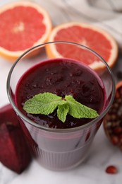 Fresh beetroot smoothie with mint in glass on white table, closeup