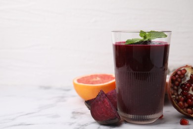 Tasty beetroot smoothie and fresh products on white marble table, closeup. Space for text