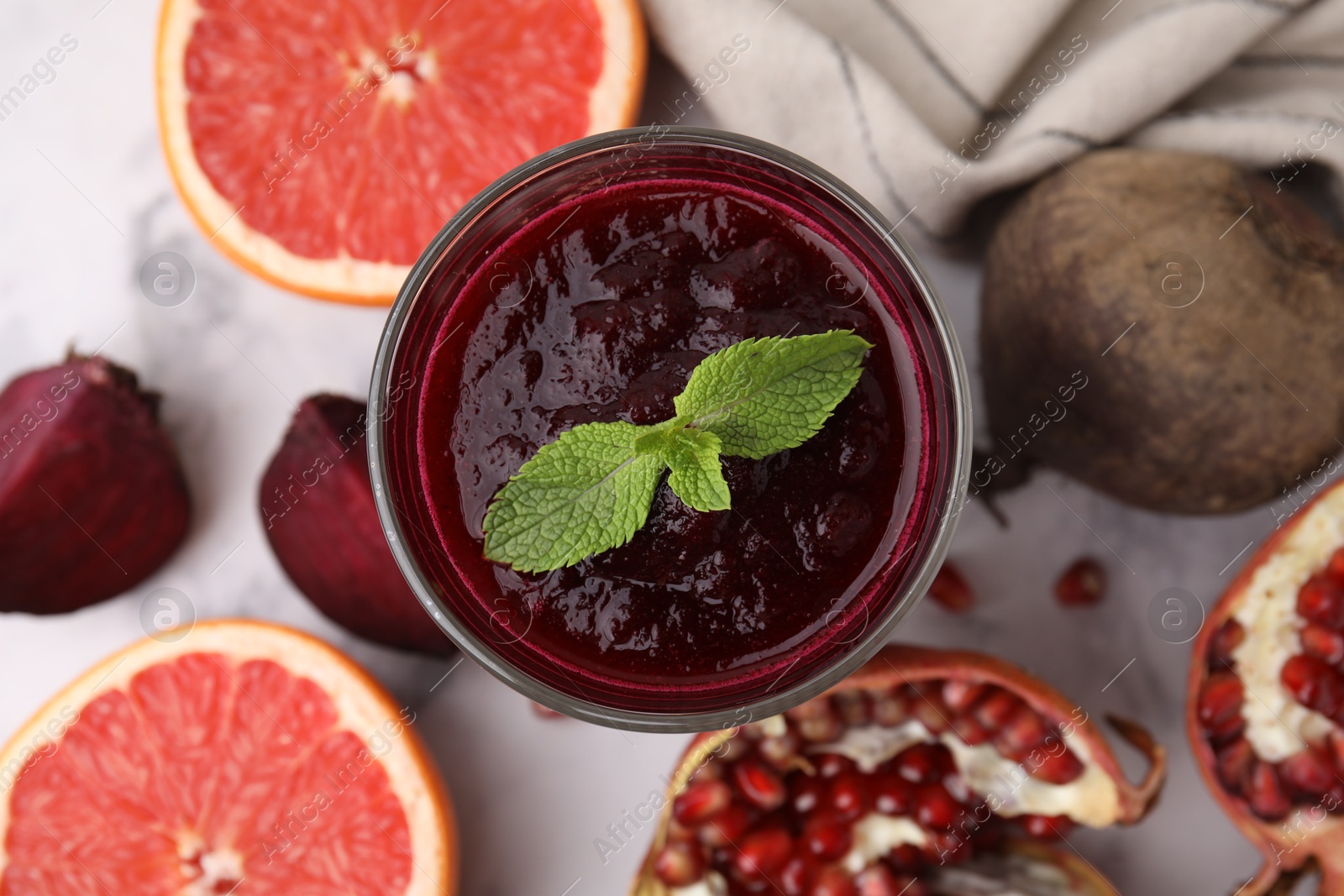 Photo of Fresh beetroot smoothie and mint in glass on white table, flat lay