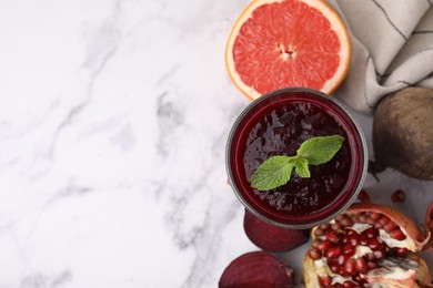 Fresh beetroot smoothie, grapefruit, beet and pomegranate on white marble table, flat lay. Space for text