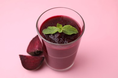 Photo of Fresh beetroot smoothie in glass and beet on pink table. Vegan drink