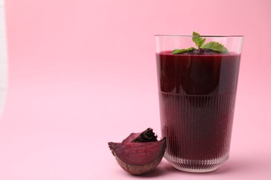 Photo of Fresh beetroot smoothie in glass and beet on pink table, closeup. Space for text