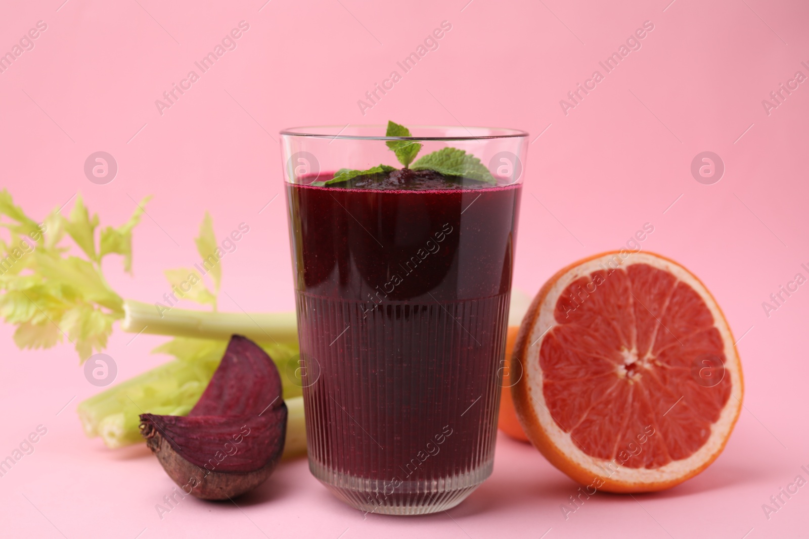 Photo of Tasty beetroot smoothie and fresh products on pink table