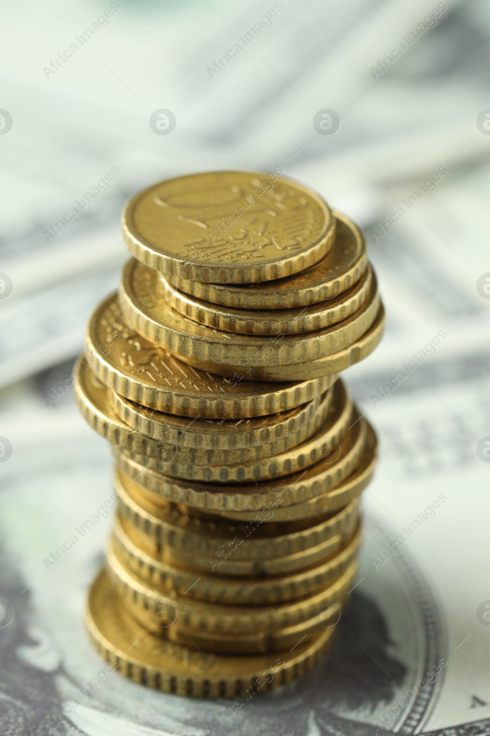 Photo of Stacked euro coins on dollar banknotes, closeup