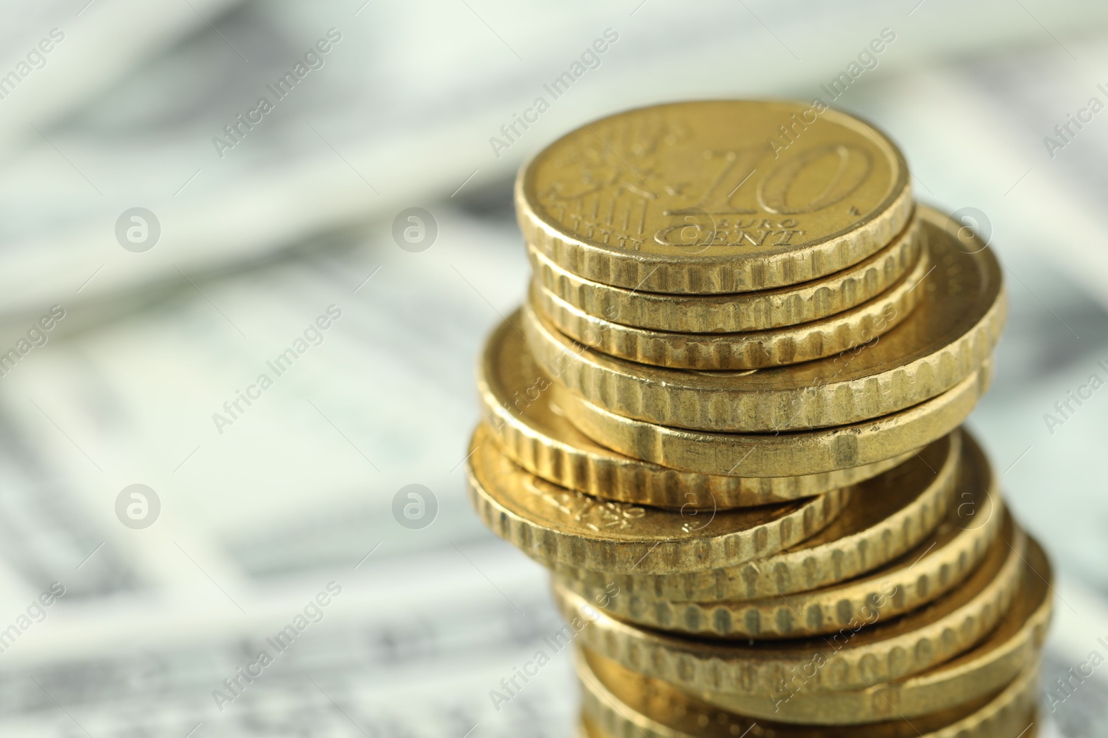 Photo of Stacked euro coins on dollar banknotes, closeup. Space for text