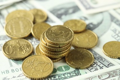 Photo of Many euro coins on dollar banknotes, closeup