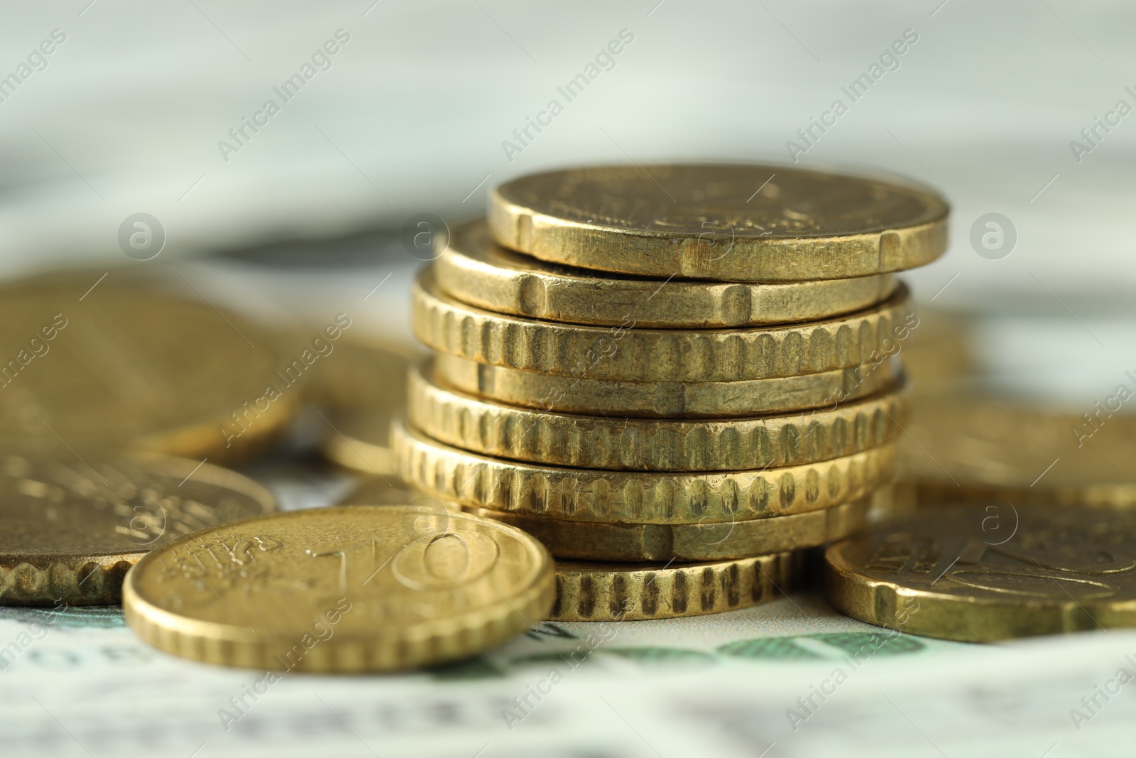 Photo of Many euro coins on dollar banknotes, closeup