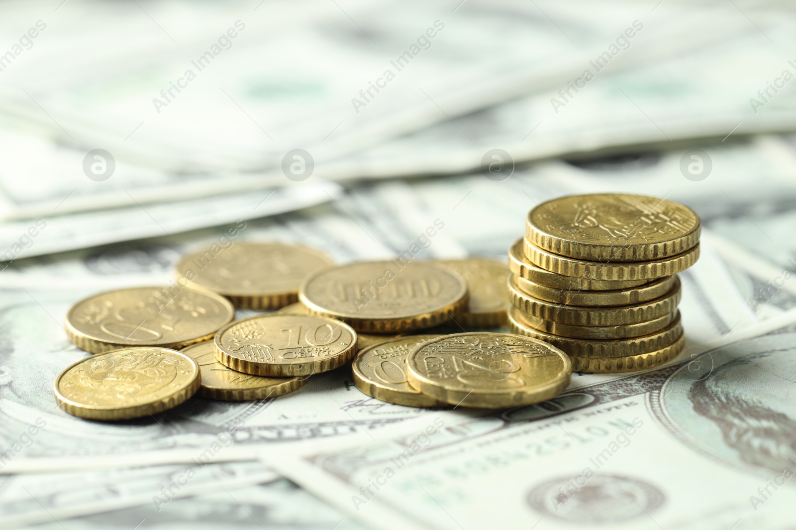 Photo of Many euro coins on dollar banknotes, closeup