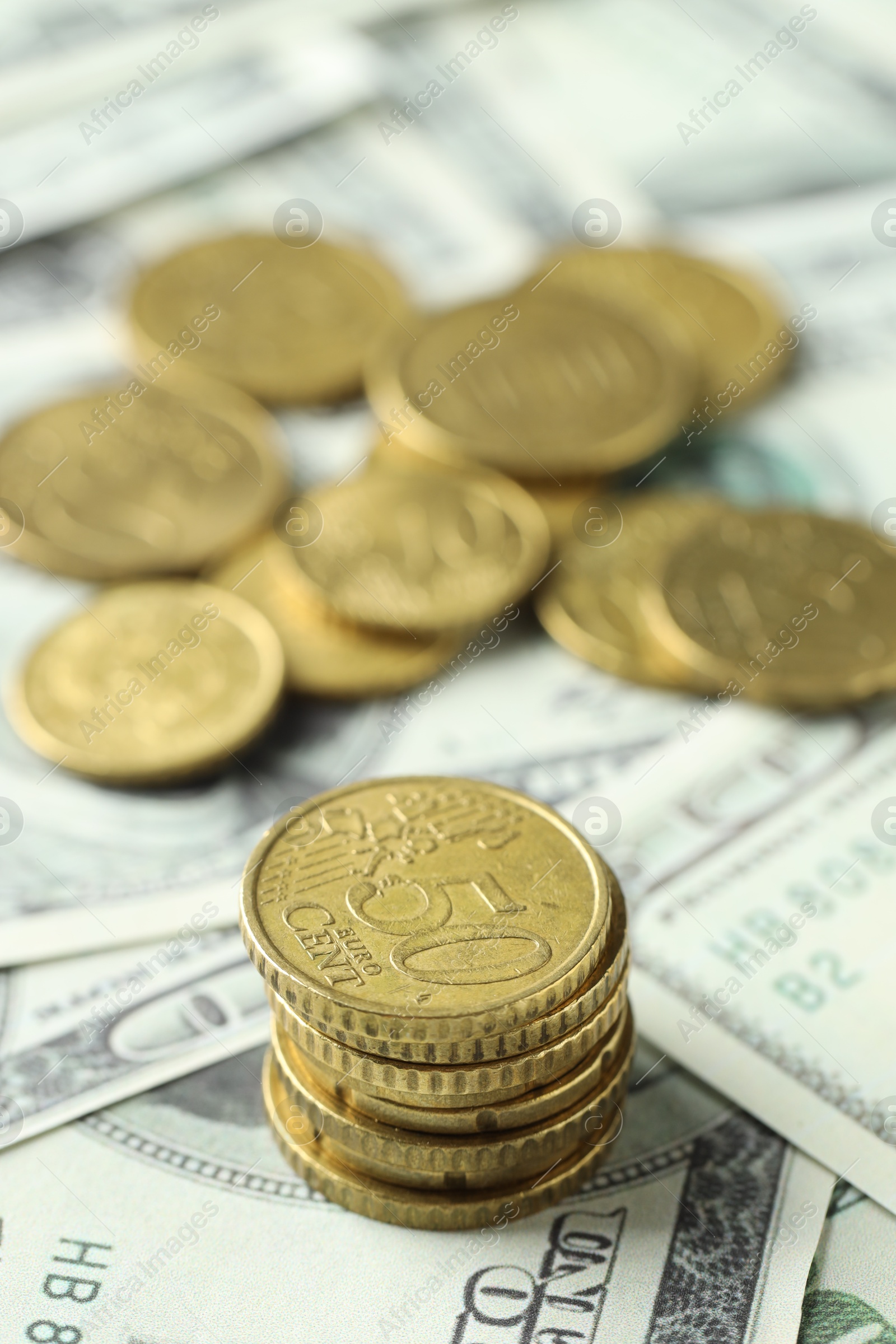 Photo of Many euro coins on dollar banknotes, closeup