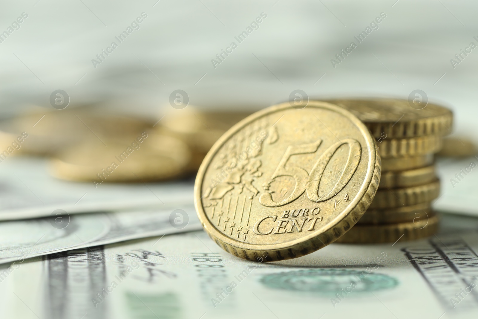 Photo of Many euro coins on dollar banknotes, closeup. Space for text